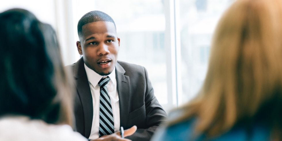 Businessperson in suit talking to two other employees