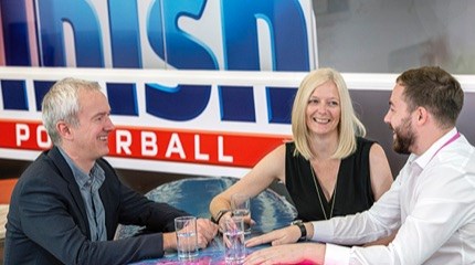 Three employees sitting round a table in the Finish office