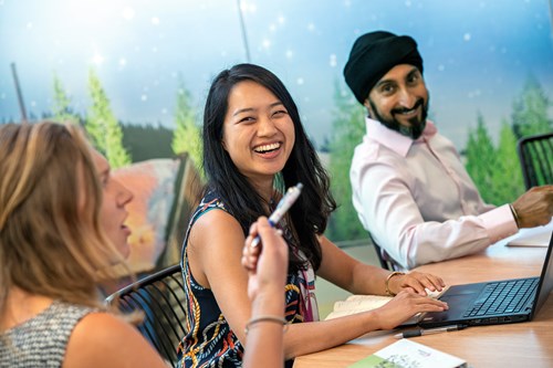 Diverse group of employees sitting around table in a meeting room