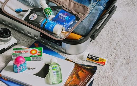 Reckitt brands' products spill out of a suitcase that is packed for a holiday - Airborne, Nurofen, Gaviscon, Dettol, Veet and Durex