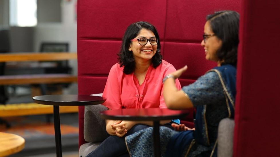 Two women colleagues talking around a table