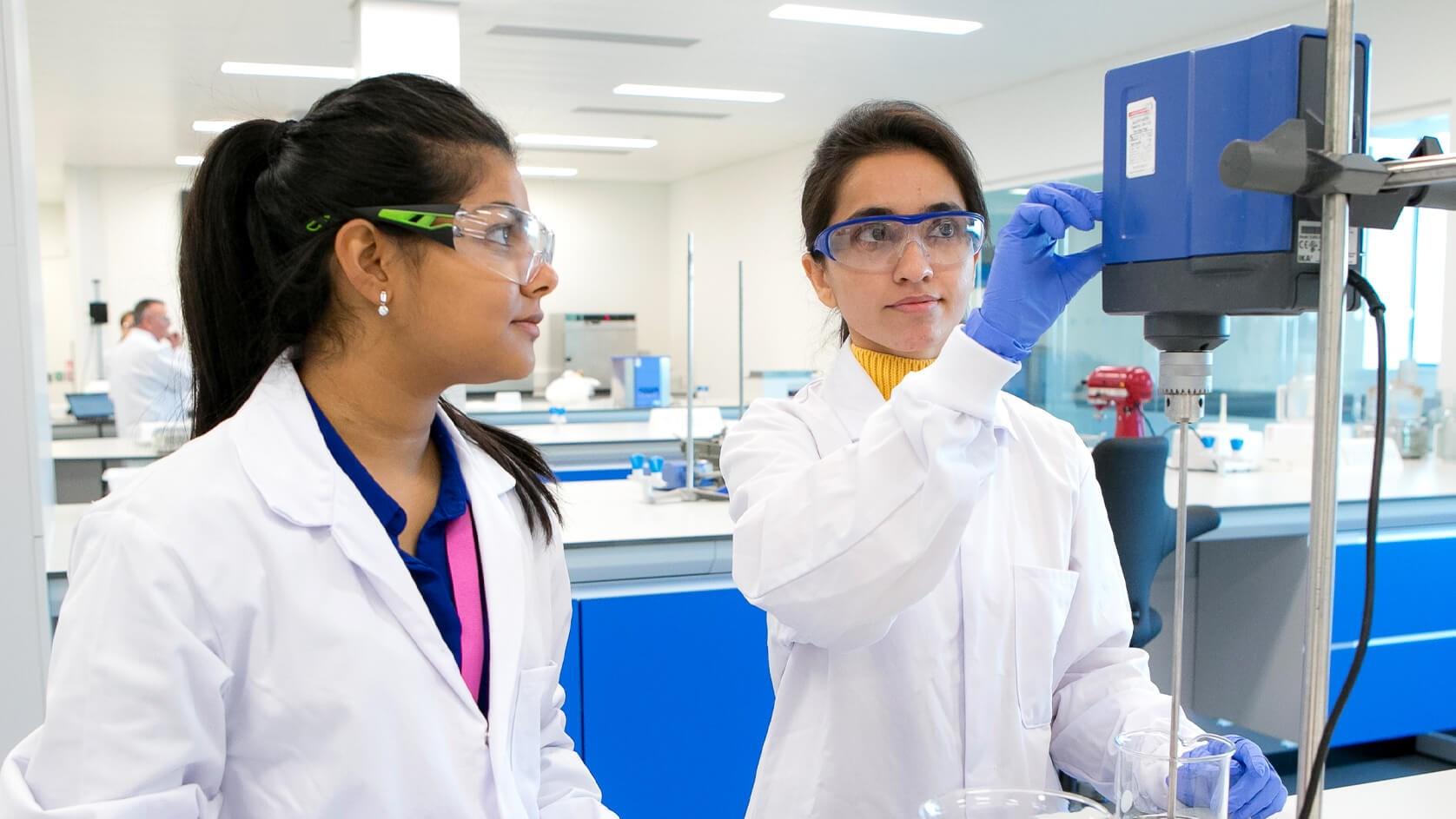 Two Reckitt employees working in a lab in safety gear