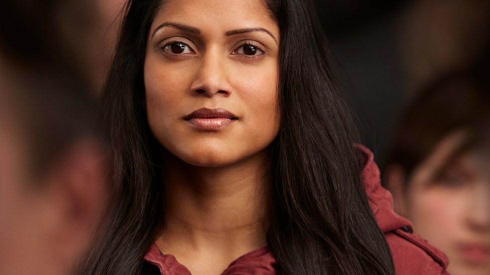 Portrait of a beautiful Asian woman, standing in a crowd.