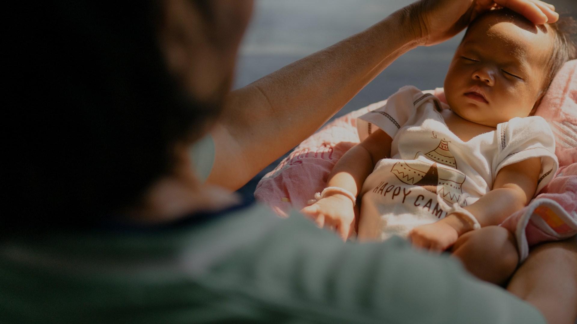 A woman holding a new born baby.