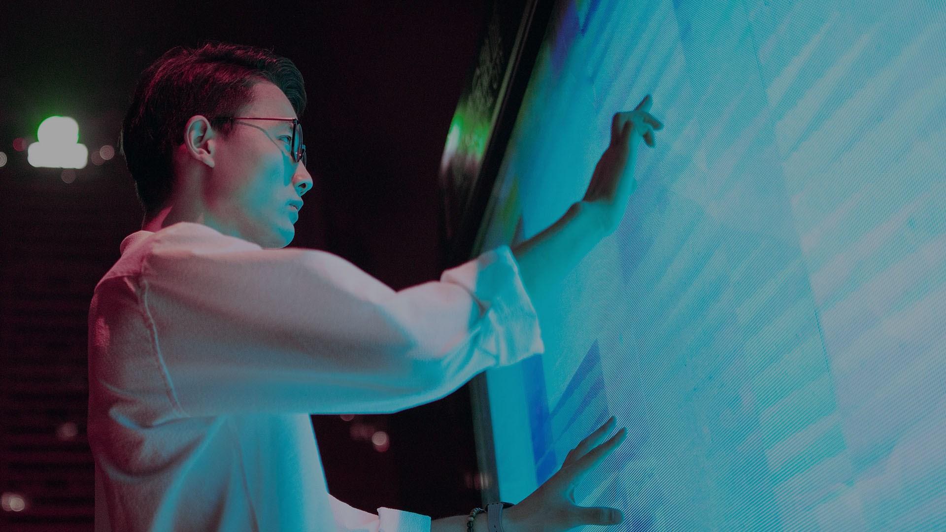 A man standing in front of a large LED screen.