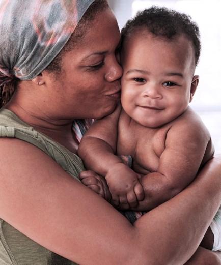 A Mother kissing her infant son.