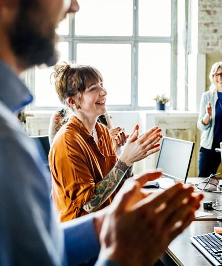 Business people applauding to colleague in office