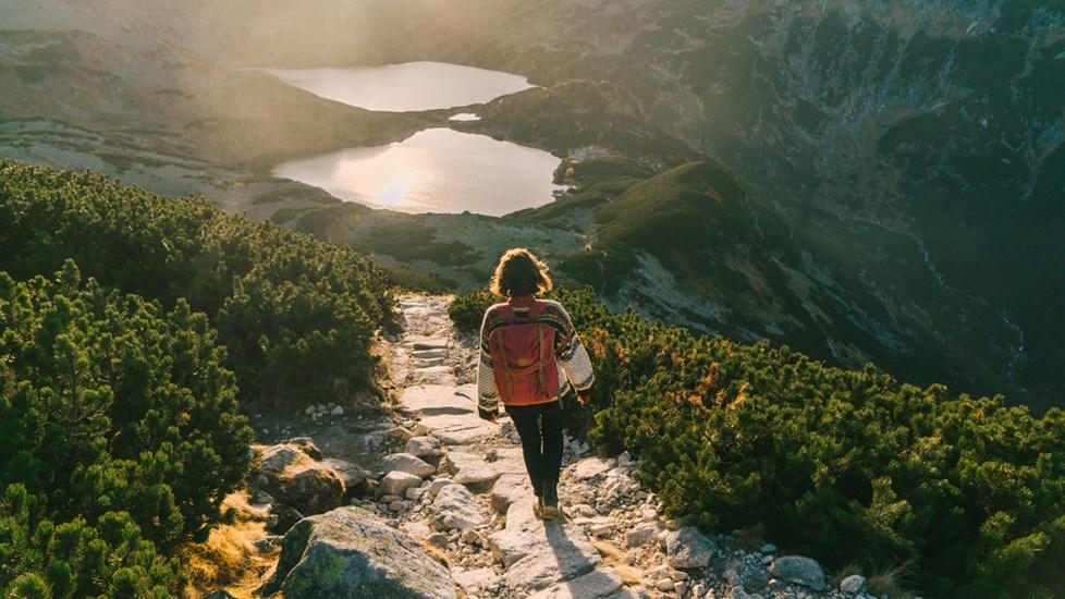 Young Caucasian woman walking near Morksie Oko lake in mountains in Poland.